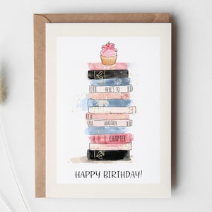 Pode incluir: Cartão de aniversário com uma ilustração de uma pilha de livros encimada por um cupcake. Os livros são de várias cores, com as palavras "Here's to Another Chapter". O cartão diz "Happy Birthday!"
