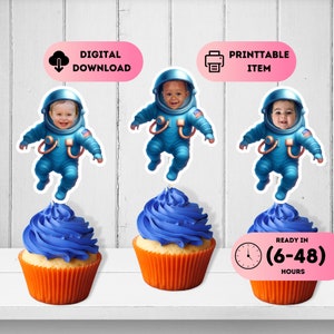 May include: Three blue and white astronaut cupcake toppers with a space theme. Each topper features a child's face in the helmet. The toppers are on top of cupcakes with blue frosting and orange cupcake liners. The text "DIGITAL DOWNLOAD" and "PRINTABLE ITEM" are on pink and white labels above the toppers. The text "READY IN (6-48) HOURS" is on a white label with a clock icon.