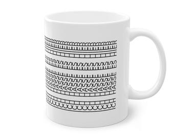 Puede incluir: Taza de cerámica blanca con un diseño de patrón tribal negro. El diseño consta de varias bandas horizontales con diversas formas geométricas y líneas. La taza tiene un asa estándar y un acabado brillante.