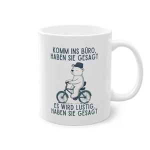 Könnte beinhalten: Weiße Keramiktasse mit einer Schwarzweißillustration eines Eisbären, der Fahrrad fährt. Der Text auf der Tasse lautet "Komm ins Büro, haben Sie gesagt. Es wird lustig, haben Sie gesagt."
