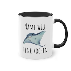 Könnte beinhalten: Ein weißer Keramikbecher mit schwarzem Innenraum und Henkel. Auf der Vorderseite befindet sich eine Cartoon-Illustration eines blauen Rochen, der eine Zigarette raucht, zwischen dem schwarzen Text "NAME WILL" oben und "EENE ROCHEN" unten.