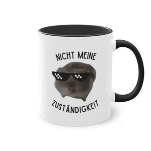 Pode incluir: Caneca de cerâmica branca com borda e alça pretas. A caneca apresenta uma imagem em preto e branco de uma criatura usando óculos de sol com o texto "Nicht Meine Zuständigkeit" em preto.