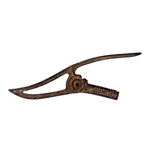 May include: An antique, rusty metal tool with a curved design. The tool has a circular joint in the center and the text "WHITE'S CHICAGO" is visible on the handle. The tool is likely used for a specific mechanical purpose.