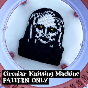 May include: A black and white knit beanie with a skull design, set inside a circular knitting machine. The text "Circular Knitting Machine PATTERN ONLY" is displayed at the bottom of the image. The beanie features yellow eyes.