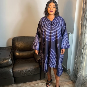 May include: A long, blue and white tie-dye dress with a V-neckline and long sleeves. The dress is loose-fitting and has a flowing silhouette.