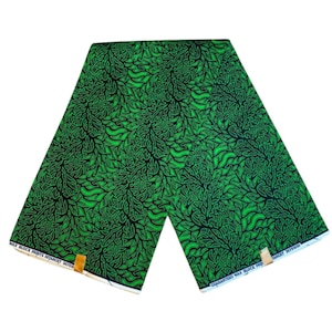 Peut inclure: Tissu vert et noir avec un motif de feuilles. Le tissu a une étiquette blanche avec le texte "Guaranteed Wax Block Prints Int'l Target 36"yards".