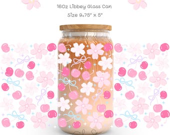 Może przedstawiać: Przezroczysty szklany słoik z drewnianą pokrywką, ozdobiony różowymi kwiatami wiśni i wiśniami. Tekst "Winky Cherry Blossom" znajduje się na górze. Słoik ma 24,77 cm wysokości i 12,7 cm szerokości.