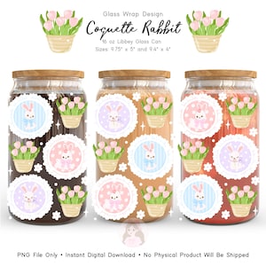 Op de afbeelding: Drie glazen potten met houten deksels, elk met een decoratief etiket met een konijn en tulpen. De tekst "Coquette Rabbit" staat boven de afbeelding. De potten zijn 24,77 cm x 12,7 cm en 23,88 cm x 10,16 cm groot.