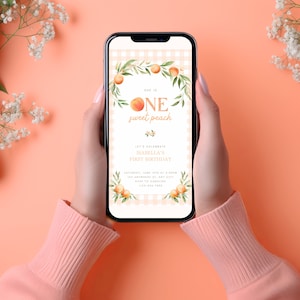 May include: A peach-themed first birthday invitation on a smartphone screen. The invitation features a peach with the text "One sweet peach" and a gingham background. The text "Let's celebrate Isabella's first birthday" is also included.