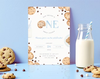 Può includere: Un invito blu e bianco a tema biscotti. La carta dice "Il nostro Trevor ha un anno, un biscotto dolce" e include i dettagli per una festa di compleanno. La carta è circondata da biscotti e latte.