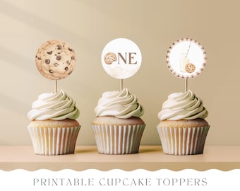 May include: Printable cupcake toppers featuring a chocolate chip cookie, a milk bottle with a cookie, and the word "ONE" in a brown and white colour scheme.