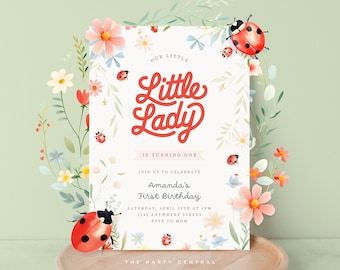 May include: A white invitation card with a floral design and ladybugs. The text reads "Our Little Lady is turning one. Join us to celebrate Amanda's First Birthday. Saturday, April 23rd at 4pm. 1345 Anywhere Street. RSVP to Mom. The Party Central."