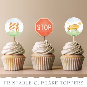May include: Three printable cupcake toppers featuring a construction theme. The toppers are round and feature a yellow dumper truck, a stop sign, and a construction barricade.