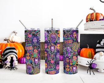May include: Three stainless steel tumblers with colorful, graphic designs of horror movie characters. The tumblers are on a white surface with pumpkins and other Halloween decorations.