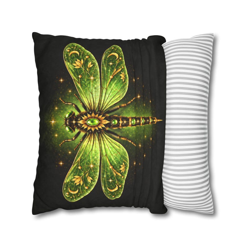 May include: A rectangular throw pillow featuring a black front panel with a large, detailed green and gold dragonfly illustration adorned with stars, moons, and floral motifs. The side panel displays a white and grey horizontal striped pattern.