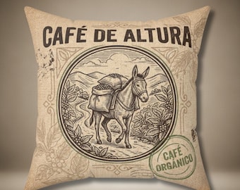 Puede incluir: Cojín cuadrado de arpillera con temática de café vintage. El cojín presenta una ilustración circular de un burro que lleva sacos de granos de café, con el texto "CAFÉ DE ALTURA" y "CAFÉ ORGANICO". El diseño es en tonos marrones y beige.