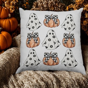 Peut inclure: Un coussin carré à fond blanc orné d'un motif répétitif composé de citrouilles orange avec des nœuds à carreaux noirs et blancs et de fantômes blancs décorés de petites fleurs noires, disposés en une grille de neuf icônes distinctes.