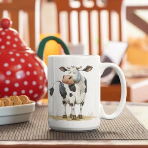 May include: White ceramic mug with a black and white cartoon cow illustration. The cow is looking to the left and has a surprised expression. The mug has a handle on the right side.