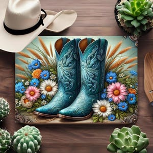 May include: A pair of turquoise cowboy boots with intricate floral designs, set against a backdrop of wildflowers and wheat. A white cowboy hat with a black band rests above the boots. The boots are a focal point, showcasing a blend of rustic and artistic elements.