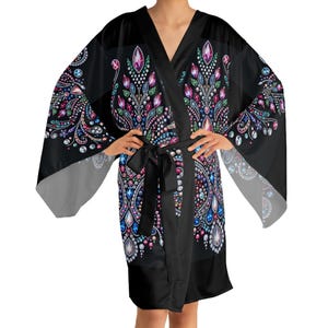 Può includere: Accappatoio kimono nero con un colorato design gioiello. L'accappatoio presenta uno scollo a V, maniche larghe e una cintura abbinata. Il motivo gioiello include accenti rosa, blu, verdi e viola, creando un look vibrante ed elegante.