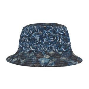 May include: A blue bucket hat featuring a rose floral pattern on the crown and a denim patchwork design on the brim. The hat is made of quilted fabric and has a classic, casual style.