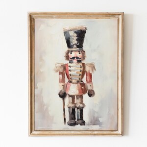 Puede incluir: Una pintura de un juguete tradicional de cascanueces de madera. El cascanueces lleva un uniforme rojo y blanco con ribetes dorados y un sombrero negro con una pluma. El fondo es gris claro.