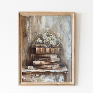 May include: A framed painting of a stack of old books with a bouquet of white flowers on top. The books are brown and have gold lettering. The background is a muted brown and blue.