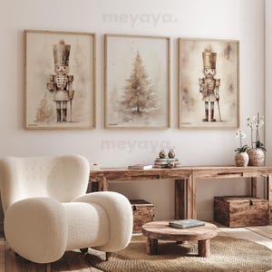 May include: Three framed watercolor illustrations of a Christmas tree and two nutcracker soldiers. The illustrations are in shades of brown and white and have a vintage feel. The frames are light wood.