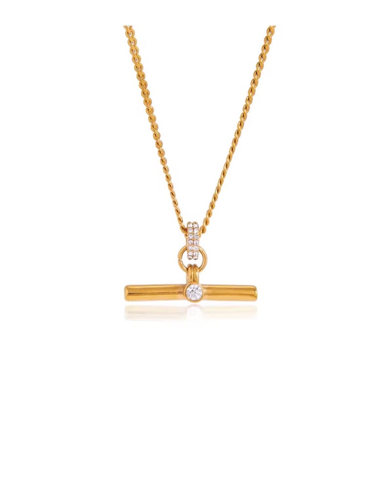 May include: Gold-toned necklace featuring a T-bar pendant with a single, clear gemstone. The pendant is suspended from a delicate chain. The necklace also has a small, circular accent with embedded gemstones.