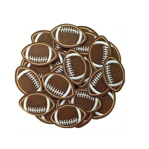 May include: A pile of brown felt football patches with white stitching. The patches are arranged in a circular pattern.