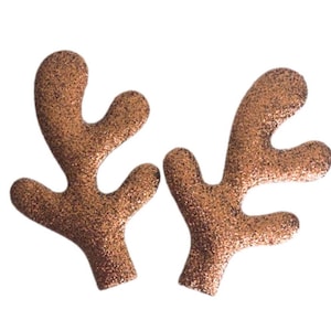May include: A pair of brown glitter reindeer antlers. The antlers are made of felt and have a sparkly finish.