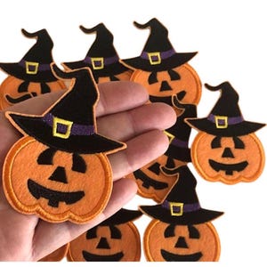 May include: Eight orange felt pumpkin patches with black eyes, noses, and mouths. Each pumpkin has a black witch hat with a purple band and a yellow buckle.