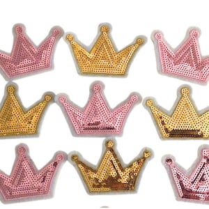 May include: Eight gold and pink sequined crown patches. The crowns are all the same shape and size, but alternate in color.