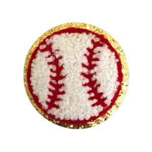 May include: A white and red baseball with a gold glitter border. The baseball is made of a fuzzy material.