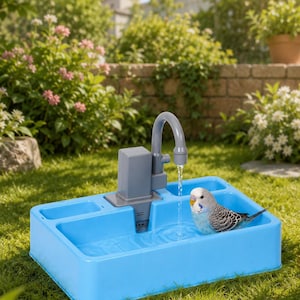 Puede incluir: Un bebedero azul con un grifo gris y un pequeño periquito dentro. El bebedero es rectangular y tiene una bomba de agua. La escena está ambientada al aire libre, en una zona de césped con flores y un muro de ladrillo al fondo.