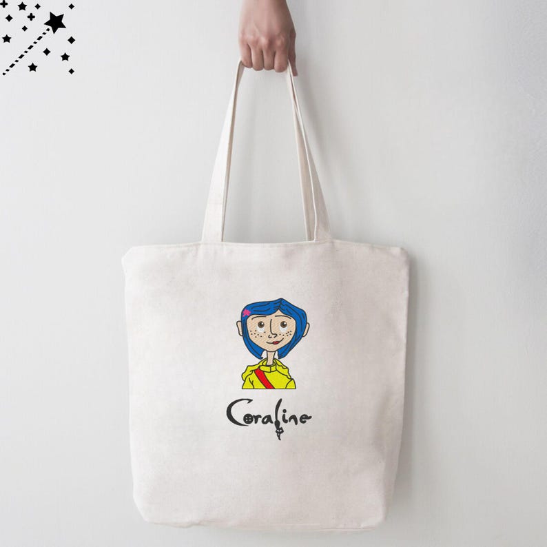 May include: A white canvas tote bag with a cartoon illustration of Coraline from the movie Coraline. The illustration is in color and features Coraline with blue hair, a yellow shirt, and a red scarf. The text "Coraline" is printed below the illustration.