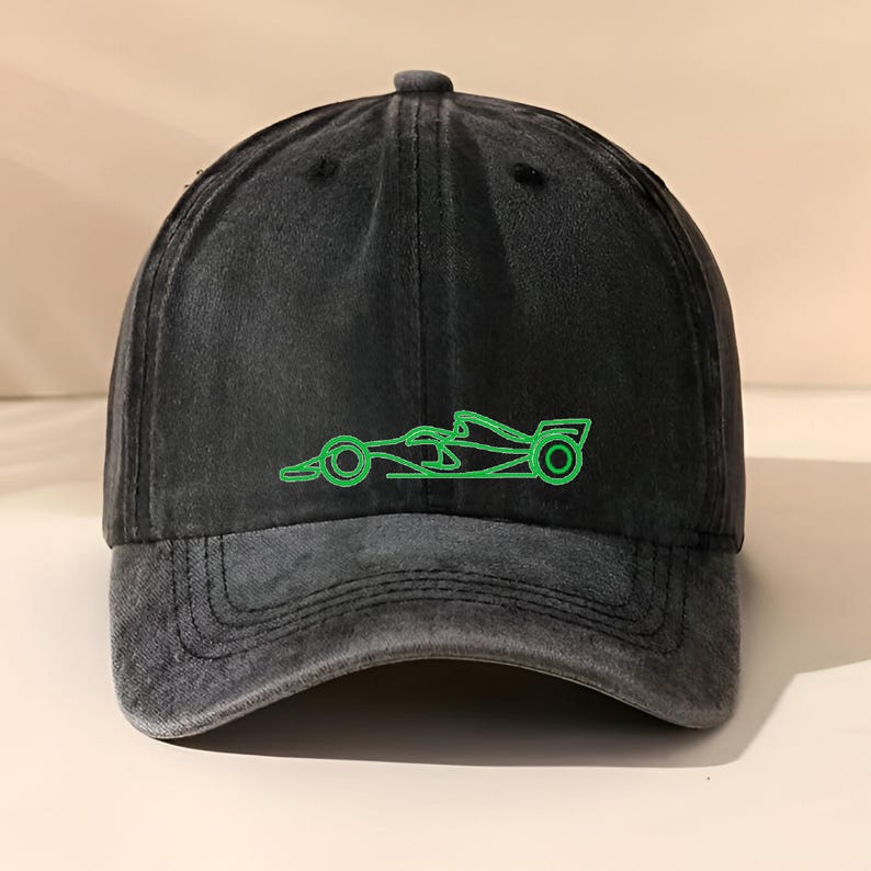 Op de afbeelding: Zwarte baseballcap met een verweerde afwerking. De cap heeft een neon groen geborduurde omtrek van een raceauto op de voorkant. De cap heeft een gebogen klep en een verstelbare band aan de achterkant.