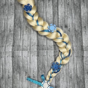 May include: A blonde braided hair accessory with blue accents and snowflake embellishments. The braid is adorned with blue ribbons and glittery snowflake decorations, perfect for themed events or costumes.