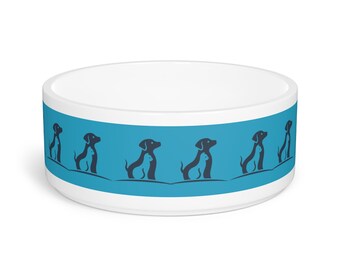 Puede incluir: Tazón de cerámica blanco para perros con una banda azul que presenta un patrón repetido de siluetas negras de perros. Los perros están sentados con las patas cruzadas y un perro más pequeño sentado encima de cada uno.