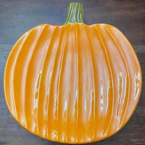 Puede incluir: Plato de servir de cerámica naranja en forma de calabaza con un acabado brillante.