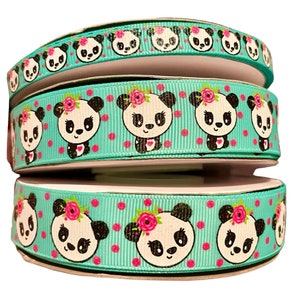 Könnte beinhalten: Drei Rollen türkisfarbenes Band mit weißen Punkten und Pandabären-Gesichtern mit rosa Blumen. Die Pandabären haben schwarze Augen und Nasen.