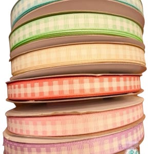 Könnte beinhalten: Eine Rolle mit sechs Gingham-Bändern in verschiedenen Pastellfarben, darunter hellblau, grün, gelb, orange, rosa und lila.