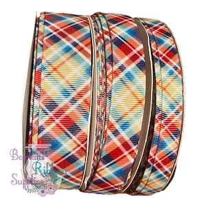 May include: A roll of red, blue, yellow, and white plaid ribbon. The ribbon has a woven texture and is perfect for crafting and decorating.