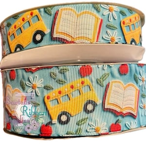 May include: A blue and white ribbon with a repeating pattern of yellow school buses, red apples, open books, and white daisies.