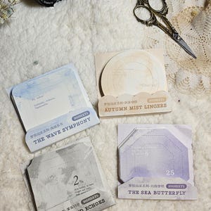 May include: Three packs of decorative paper stickers with watercolour designs. Each pack contains 30 sheets of stickers with different shapes and sizes. The packs are labelled "The Wave Symphony", "Misty Island Echoes", and "The Sea Butterfly".