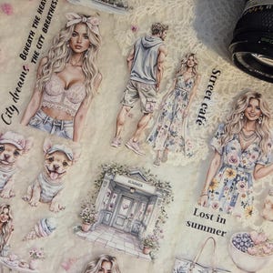 May include: A collection of paper cutouts with a summer theme. The illustrations include fashion figures, puppies, cityscapes, and floral elements. Text includes "City dreams", "Street cafe", "Summer", "Lost in summer", and "City Heat". A vintage camera is in the background.