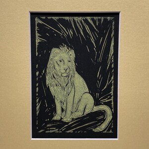 Golden lion block printed on black paper.