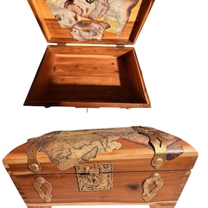 May include: A wooden treasure chest with a hinged lid, featuring a map design on the lid's interior and exterior. The chest has brass hardware, including a clasp and corner accents. The open chest reveals an empty interior.