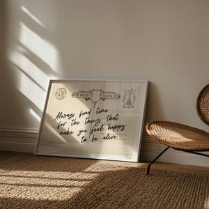 Puede incluir: Impresi&oacute;n enmarcada con un dise&ntilde;o de postal vintage. El texto dice "Always find time for the things that make you feel happy to be alive." La impresi&oacute;n est&aacute; en un marco blanco, apoyada contra una pared.