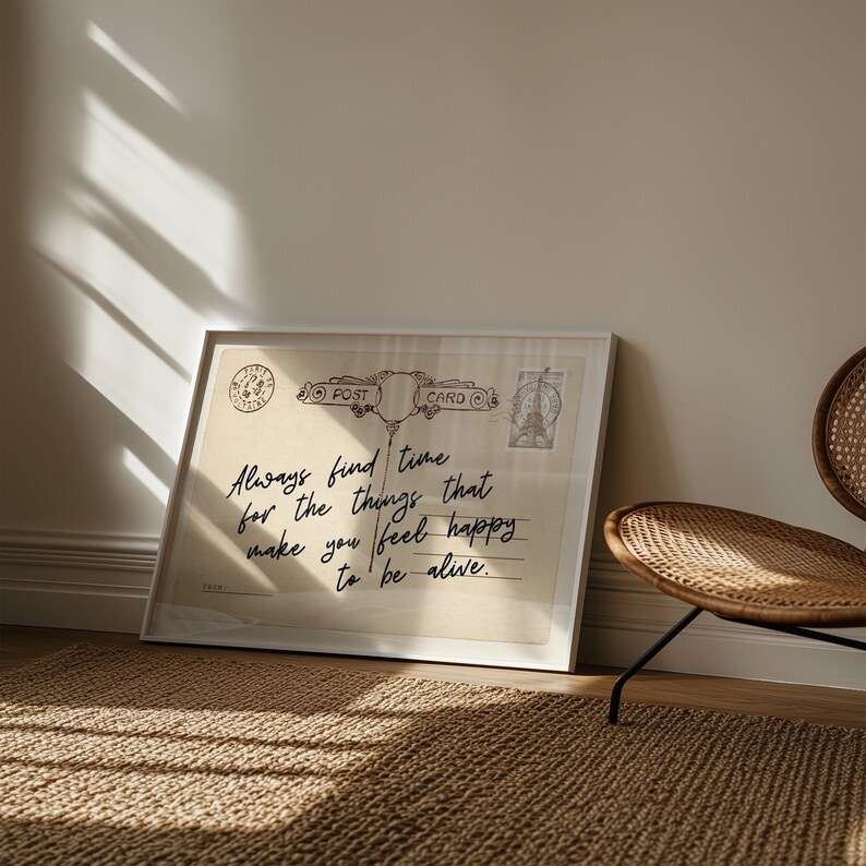 Puede incluir: Impresi&oacute;n enmarcada con un dise&ntilde;o de postal vintage. El texto dice "Always find time for the things that make you feel happy to be alive." La impresi&oacute;n est&aacute; en un marco blanco, apoyada contra una pared.